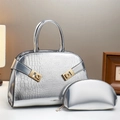 Silver crocodile textured handbag set with golden buckles in a warm interior setting - Silver