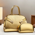Close-up of gold croc-embossed handbag set with polished metallic hardware detail - Gold