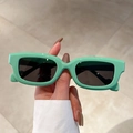 Chic mint green square frame sunglasses with dark grey lenses in a handheld display view - Solid Green / Grey Lenses
