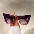 Close-up of cat-eye sunglasses with purple gradient frames on marble background - Purple Frame Gradient Grey Lens
