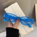 Detailed shot of cat-eye sunglasses with blue glitter translucent frame on a case - Transparent Blue Frame Blue Lens