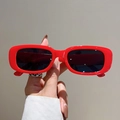 Dettaglio di occhiali da sole vintage rossi rettangolari con montatura lucida e lenti UV - Montatura Rossa Lenti Grigie