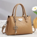 Close-up of woven texture and decorative metal keychain on tan crossbody handbag - Khaki