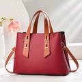 Detail of burgundy pebbled leather handbag with brown handles and gold hardware - Wine Red