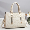 Close-up of cream white trapezoid tote bag with marble pattern and gold hardware - Off White