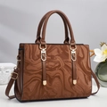 Detail of brown tote bag showing marble water ripple texture and gold hardware accents - Brown