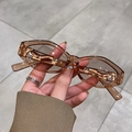 Handheld transparent amber leopard print sunglasses with irregular oval frames - Light Tea