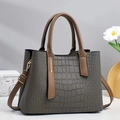 Detail of gray crocodile pattern leather bag with contrast brown strap and gold hardware - Gray