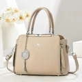 Dettaglio borsa beige texture litchi con logo e ciondolo in metallo dorato lucido - Albicocca