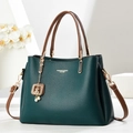 Deep green pebble leather handbag with brown handles and a gold pearl charm on white decor - Green