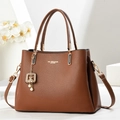 Fashionable brown pebble leather tote bag with gold hardware and pearl charm on display - Earthy Yellow