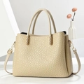 Detail of beige textured tote bag with golden hardware and adjustable crossbody strap - Light Khaki