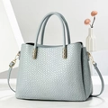 Dettaglio della borsa tote grigio-azzurra con trama a coccodrillo ed eleganti finiture dorate - Blu