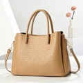 Dettaglio macro della trama intrecciata kaki e hardware dorato su borsa tote elegante - Cachi Scuro
