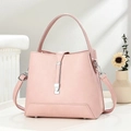 Detail of pink pebbled leather handbag featuring silver hardware and protective metal feet - Pink