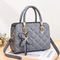 Elegant grey quilted crossbody bag with golden hardware and leather butterfly charm - Gray