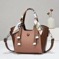 Detail of a brown leather tote bag with twill fabric panel and a silk scarf wrapped handle - Coffee