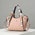 Detail of pink lychee leather crossbody bag with decorative scarf and silver hardware - Pink