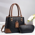 Borsa tote in pelle nera intrecciata con finiture marroni e logo dorato su sfondo grigio - Nero