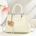 Elegant beige commute handbag with lychee texture and cute bear pendant on white background - Off-white