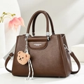 Elegant dark brown leather handbag with luxury pebble texture and plush bear charm - Coffee