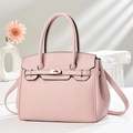 Pale pink lychee grain handbag with gold twist lock and shoulder strap on white background - Pink