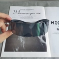 Detail der dunkelgrauen Cyberpunk-Visier-Sonnenbrille vor einem Modemagazin - Grau