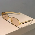 Detailed view of vintage oval sunglasses with golden metal frame and light brown lenses - Gold Frame Champagne Lens