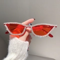 Cat eye sunglasses with red lenses and crystal rhinestones shown in hand display - Red Frame Red Lens White Diamond