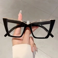 Dettaglio di occhiali cat-eye neri grandi con barra superiore a V in metallo dorato - Nero Classico