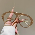 Dettaglio di occhiali stile aviator con montatura champagne e barra in metallo - Montatura Marrone Trasparente Lente Trasparente