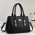 Close-up of black litchi pattern leather tote bag with gold chain and metal hardware - Black