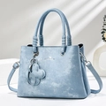 Detail of light blue vintage tote bag featuring silver hardware and flower charm - Blue