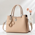 Detail of beige litchi grain tote bag with butterfly pendant and floral tassel charm - Khaki