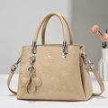 Detalle de bolso tote beige en ante sintético con logotipo y colgante de trébol - Caqui