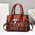 Elegant red patent leather handbag with leopard print panel and silver lock detail - Red
