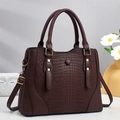 Gros plan du sac cabas marron foncé à motif crocodile avec des finitions dorées - café