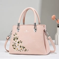 Borsa tote rosa con ricami floreali e manici in argento su uno sfondo minimalista - Rosa
