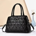 Elegante borsa a mano nera con trapuntatura a triangolo e finiture dorate su sfondo moderno - Nero
