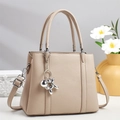 Sac fourre-tout beige en cuir avec breloque chien ballon argenté dans un décor moderne - Khaki