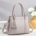 Detail of grey pebbled leather tote bag with silver balloon dog charm and crossbody strap - Apricot
