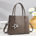Detail of taupe pebbled leather tote with silver hardware and balloon dog charm - Gray