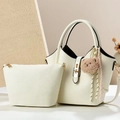 Détail du set de sacs cabas en similicuir crème avec serrure dorée et breloque ours - Blanc Cassé