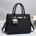 Elegante borsa a mano nera in tessuto e pelle con chiusura a rotazione dorata e mini charm - Nero