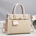 Elegante borsa beige a spina di pesce con chiusura dorata e mini ciondolo - Bianco Sporco