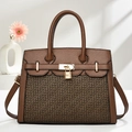 Détail du sac à main en cuir caramel avec texture grainée et cadenas en métal doré - café