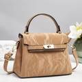 Elegant khaki marbled leather handbag with gold rotating lock and top handle on a pedestal - Apricot