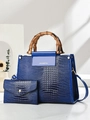 Détail du sac bleu en cuir croco avec poignées en bambou et pochette assortie de luxe - Bleu
