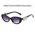 Cat eye zonnebril met zwart montuur, paarse gradiënt glazen en zilveren strik detail - Zwart Montuur Verloop Grijs Lens