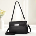 Detail of black pebbled leather texture on crossbody bag with silver twist lock - Black